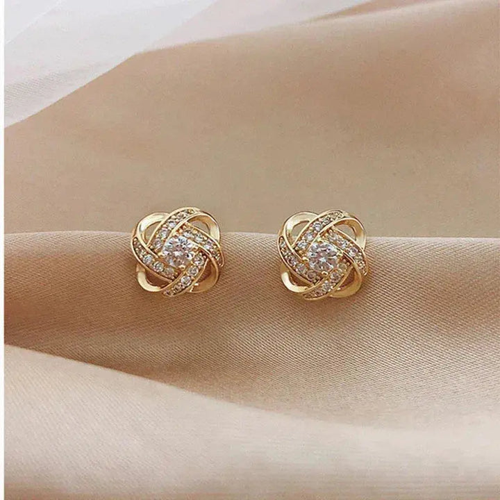 Goldene Spiral-Ohrstecker mit Blüten und Kristall